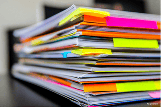 Mediaplanung in Fachzeitschriften für verschiedene Branchen Ein Stapel mit Fachzeitschriften, in denen die Veröffentlichungen des Unternehmens mit Post-its markiert wurden.